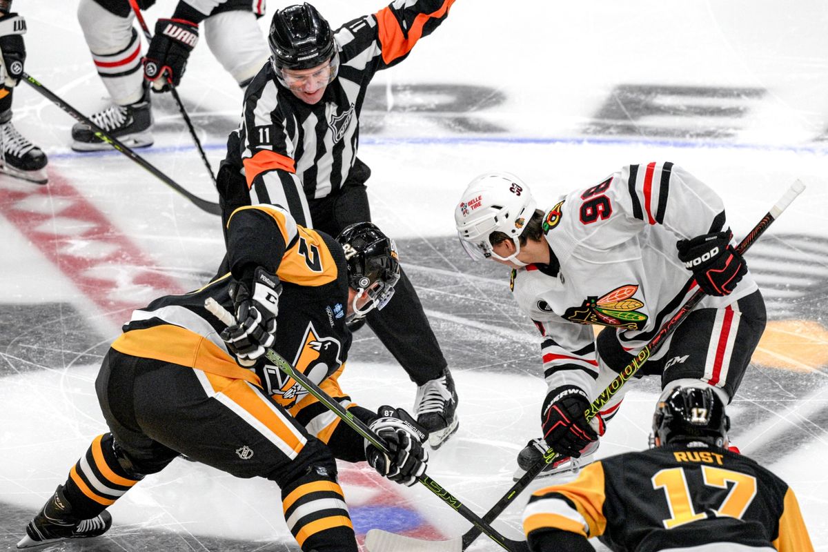 Kelly Sutherland drops the puck between Sidney Crosby and the Blackhawks' Connor Bedard to open the game.