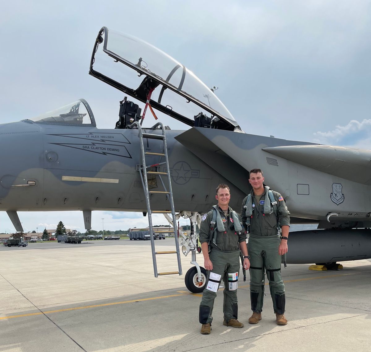 Paul Skenes, right, stands in front of an F-15 fighter jet.