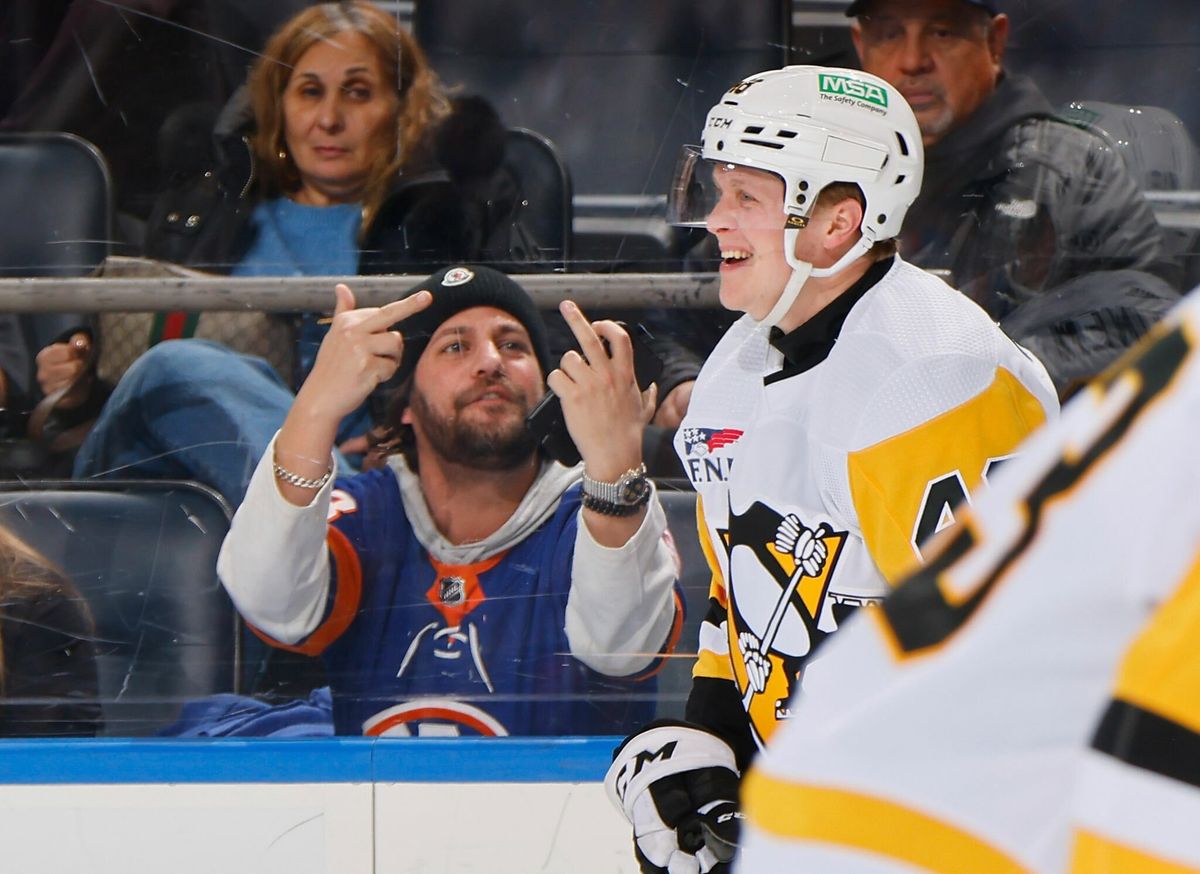 An Islanders fan congratulates Valtteri Puustinen on his two-point night Wednesday in Elmont, N.Y.